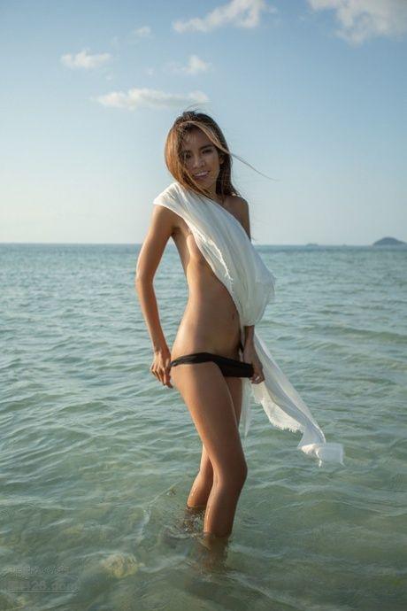 瘦瘦的宝贝玛雅迈拉炫耀她的小奶子，而完全赤裸裸的在海滩上.jpg